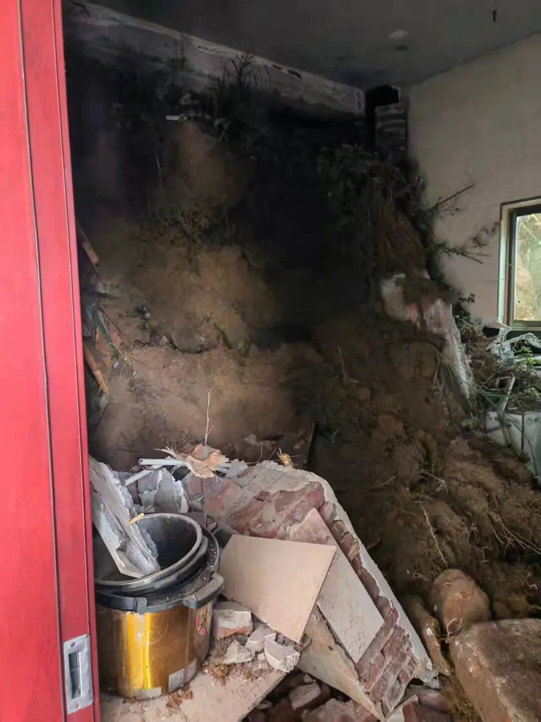 泥土冲入村民家中,屋内部分墙体及设施已被冲垮掩埋 / 受访者供图